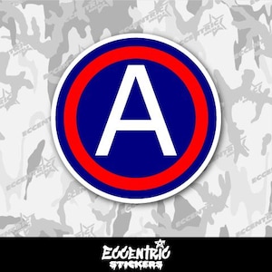 May include: A red, white, and blue circle sticker with the letter "A" in the center. The sticker is on a white camouflage background.