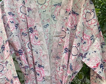 May include: A white cotton robe with a pink and blue floral print. The robe has a tie belt and long sleeves.