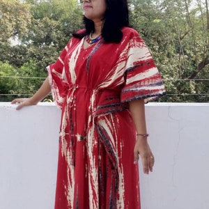 Puede incluir: Una kaftan de color rojo y blanco con estampado tie-dye y cintura con cord&oacute;n. La kaftan tiene cuello en V y mangas largas.