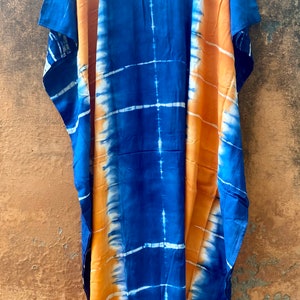 May include: A long, blue and orange tie-dye kaftan with a loose fit and short sleeves.