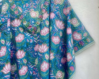 May include: A blue and pink floral print kaftan with a V-neck and short sleeves. The kaftan has a white trim around the edges.