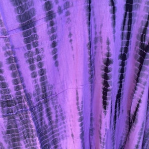 Puede incluir: Tela de tie-dye morado y negro con un patr&oacute;n vertical. La tela es suave y fluida.