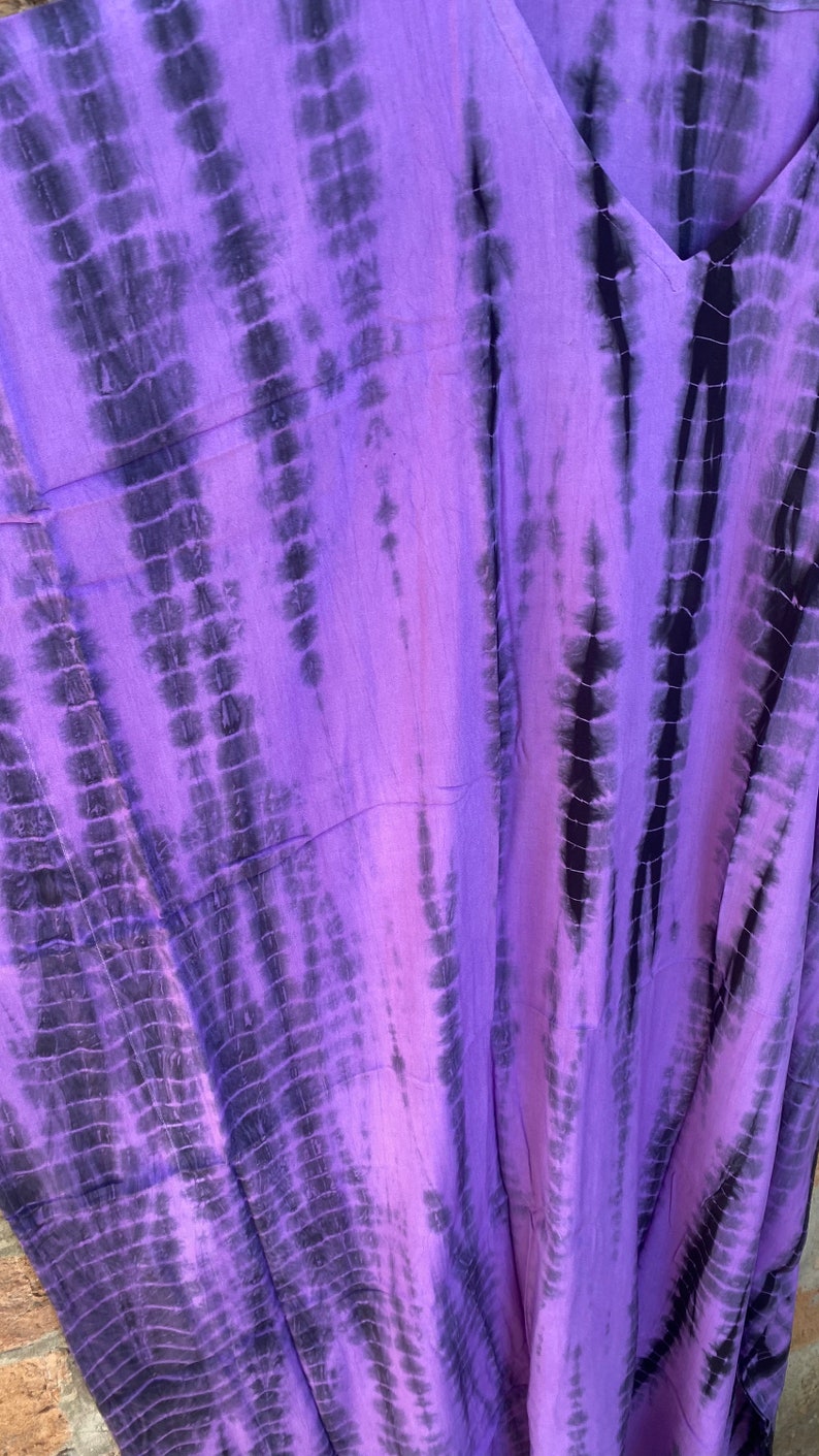 Puede incluir: Tela de tie-dye morado y negro con un patr&oacute;n vertical. La tela es suave y fluida.