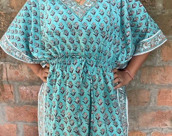 May include: A turquoise blue kaftan with a floral print and a drawstring waist. The kaftan has a V-neck and short sleeves with white trim.