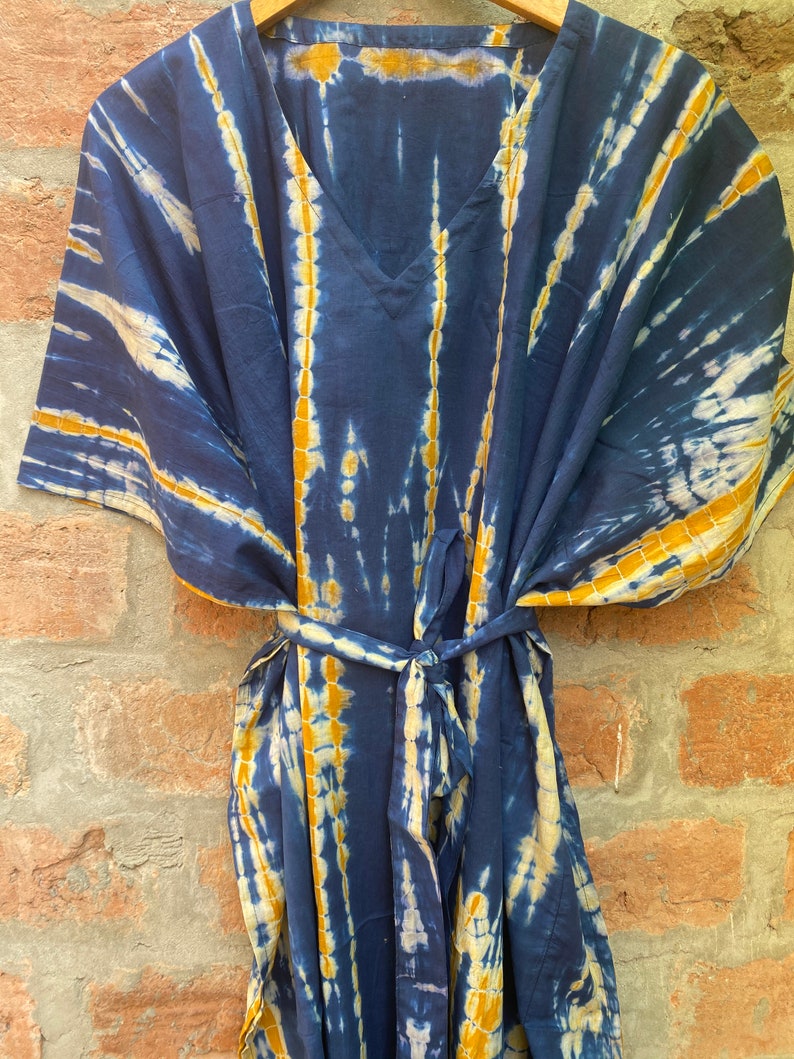 May include: A blue and yellow tie-dye kaftan with a V-neck and a tie belt.