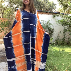 May include: A long, flowing, orange and blue tie-dye kaftan with a V-neck.