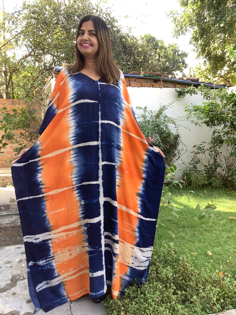 May include: A long, flowing, orange and blue tie-dye kaftan with a V-neck.
