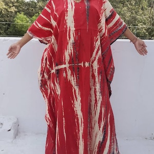 Puede incluir: Kaft&aacute;n rojo y blanco tie-dye con cuello en V y mangas largas. El kaft&aacute;n est&aacute; hecho de una tela suave y fluida y tiene un ajuste holgado.