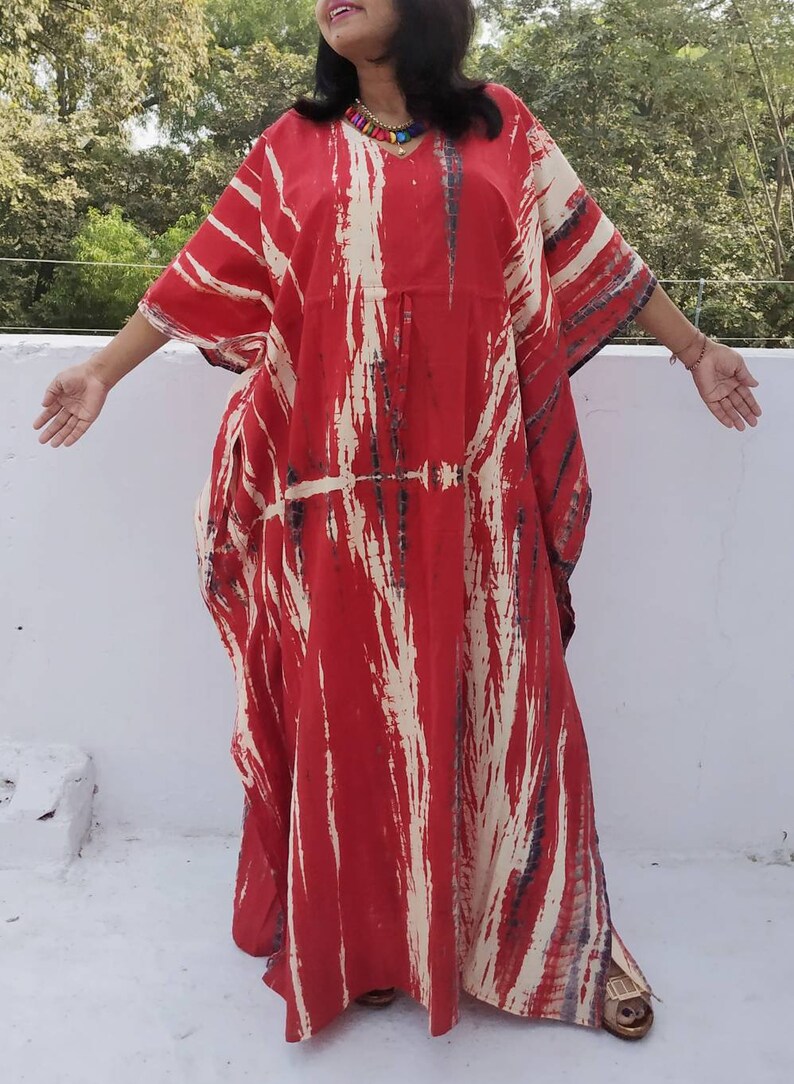 Puede incluir: Kaft&aacute;n rojo y blanco tie-dye con cuello en V y mangas largas. El kaft&aacute;n est&aacute; hecho de una tela suave y fluida y tiene un ajuste holgado.
