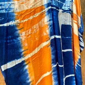 May include: A blue and orange tie-dye kaftan with a V-neck and short sleeves.