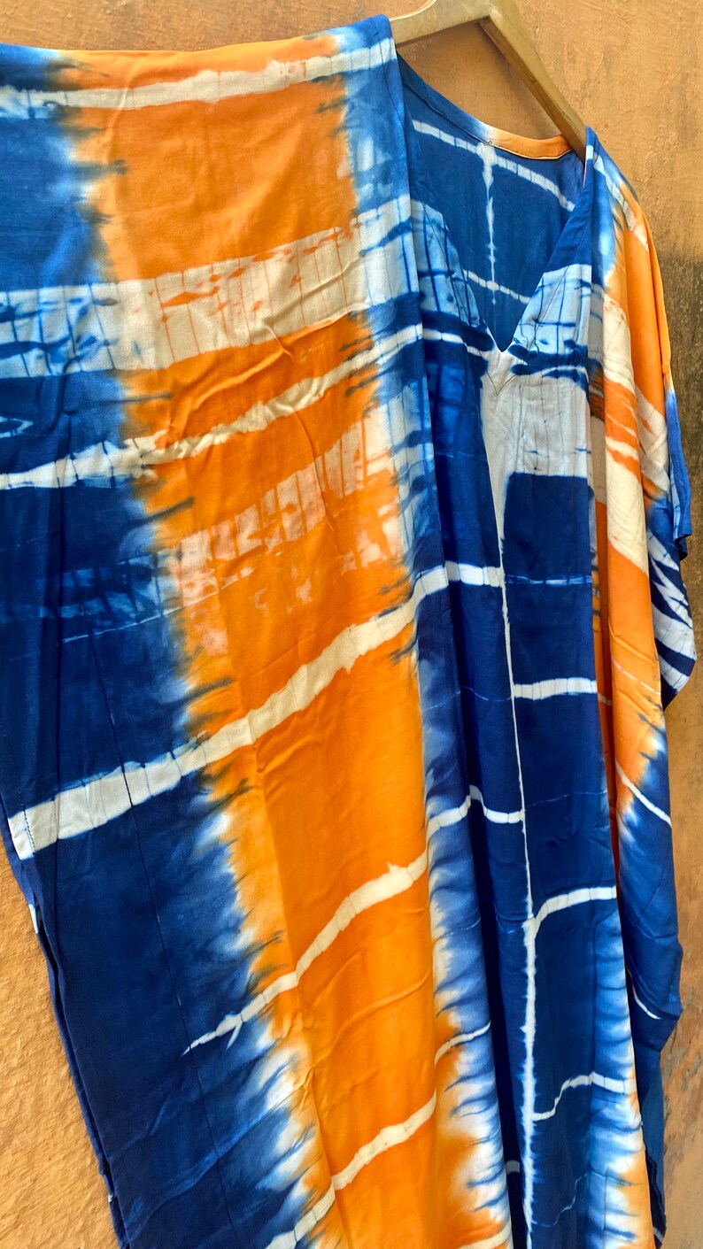 May include: A blue and orange tie-dye kaftan with a V-neck and short sleeves.