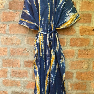 May include: A blue and yellow tie-dye kaftan with a V-neck and a tie belt.