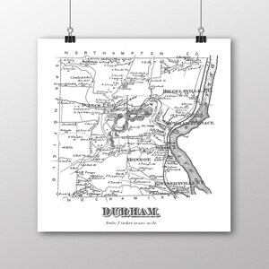 May include: A vintage black and white map of Durham, North Carolina. The map shows the town's streets, rivers, and surrounding areas. The map's title is "Durham" and the scale is "2 inches to one mile."