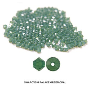 May include: A large pile of green crystal beads, with two close-up images of individual beads. The beads are faceted and have a slightly iridescent finish. The text "SWAROVSKI PALACE GREEN OPAL" is displayed below the images.