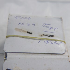 Op de afbeelding: Een wit label met blauwe inkt staat er "5400 10 x 7 Sapp 1 onss" op.