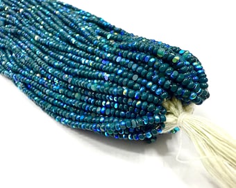 May include: A bundle of teal-colored beads with iridescent highlights. The beads are small and round, strung together, and tied with a white tassel. The beads have a glossy finish and reflect light, creating a shimmering effect.