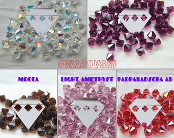 Può includere: Assortimento di cristalli bicono Swarovski 6301 in vari colori, tra cui Crystal AB, Ametista, Ametista chiaro, Padparadscha AB e Mocha. Ogni colore è mostrato in una sezione separata con una carta bianca con tre fori.