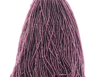 May include: A large bundle of deep purple glass seed beads. The beads are small and round, and they have a slight shimmer to them.
