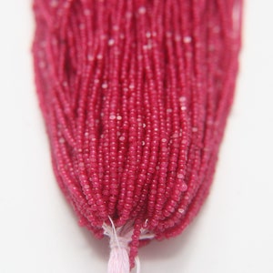 Peut inclure: Un brin de petites perles rondes de pierres précieuses rouges. Les perles sont facettées et ont un léger éclat.