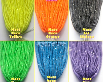 May include: Assortment of neon and jet black seed beads. The beads are arranged in rows of six colours: neon yellow, neon orange, jet black, neon green, neon electric blue, and neon purple. The beads are labelled with their colour names and the words "Neon Linings" and "True Cuts".
