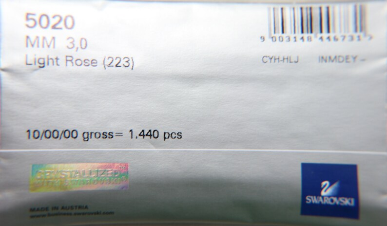 May include: Close-up of a light gray package with the text "5020 MM 3,0 Light Rose (223)". The package also includes a barcode, the text "10/00/00 gross = 1.440 pcs", and the Swarovski logo.