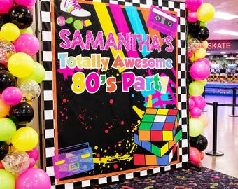 May include: A black backdrop with the text "SAMANTHA'S Totally Awesome 80's Party" in bright colors, featuring a roller skate, cassette tape, and Rubik's Cube. The backdrop is framed with a black and white checkered border and surrounded by colorful balloons.