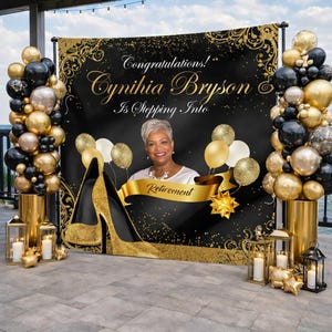 May include: A black and gold retirement party backdrop with the text "Congratulations! Cynthia Bryson Is Stepping Into Retirement". The backdrop features a cutout of a high heel shoe, balloons, and decorative accents.