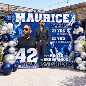 May include: A large rectangular blue backdrop featuring the name MAURICE TYSON, the text 21 YRS IN MILITARY, 21 YRS FOR GOVERNMENT, 42 YEARS, and FROM BOOTS AND DRESS SHOES TO SNEAKERS, decorated with blue and silver balloons on both sides.