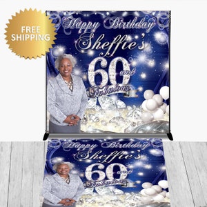 May include: A blue and silver backdrop with a photo of a woman and the text "Happy Birthday Sheffie's 60 and Fabulous". The backdrop is decorated with silver glitter and diamonds.