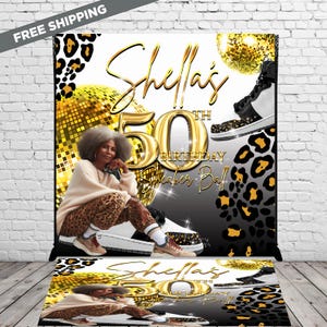 May include: A white, black, and gold birthday party backdrop with the text "Shelia's 50th Birthday Sneaker Ball". The backdrop features a disco ball, leopard print, and a woman wearing a leopard print outfit.