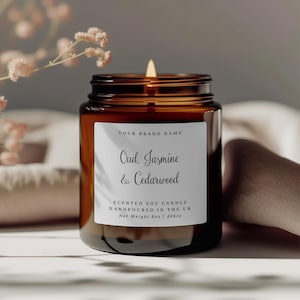 Puede incluir: Un tarro de vela de vidrio marrón con una etiqueta blanca que dice "YOUR BRAND NAME", "Oud. Jasmine & Cedarwood", "SCENTED SOY CANDLE", "HANDPOURED IN THE UK", "Net Weight 8oz | 40hrs".