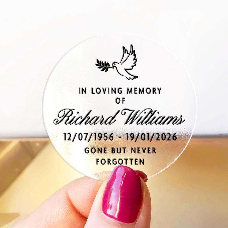 May include: A clear, round memorial sticker with black text and a dove illustration. The text reads "IN LOVING MEMORY OF Richard Williams 12/07/1956 - 19/01/2026 GONE BUT NEVER FORGOTTEN."