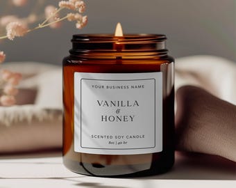 May include: An 8oz amber glass jar candle with a white rectangular label featuring the text "YOUR BUSINESS NAME", "VANILLA & HONEY", "SCENTED SOY CANDLE", and "8oz | 40 hr". The candle has a lit wick and is contained in a dark brown glass vessel.