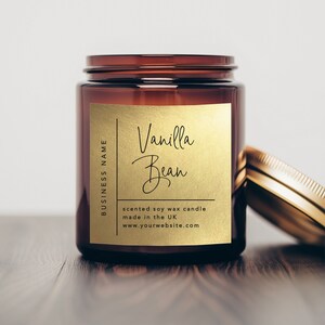 K&ouml;nnte beinhalten: Eine braune Glaskerze in einem Glas mit einem goldenen Etikett, auf dem "Vanilla Bean" und "scented soy wax candle made in the UK www.yourwebsite.com" steht.