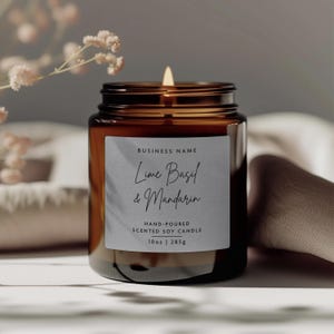 May include: A brown glass candle jar with a white label that reads "BUSINESS NAME Lime Basil & Mandarin HAND-POURED SCENTED SOY CANDLE 10oz | 285g".