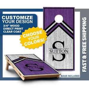 May include: Two cornhole boards featuring a wood grain texture with purple and grey sections. The boards display a large black letter S with the name SUTTON printed across it. The boards have a circular hole at the top and a 3/4 inch wood construction.