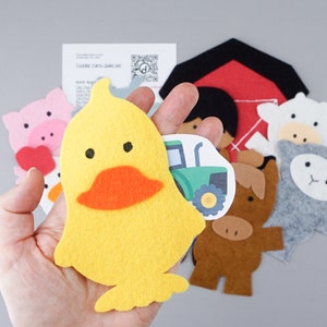 May include: A set of felt farm animal finger puppets, including a yellow duck, a pink pig, a white sheep, a gray lamb, a brown cow, and a red barn. The puppets are designed for children to use for imaginative play.