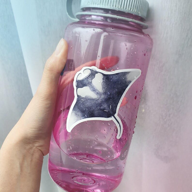 Op de afbeelding: Een roze plastic waterfles met een zwart-witte sticker van een mantarog op de zijkant.