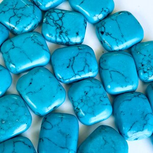 May include: A collection of smooth, turquoise blue, rectangular-shaped stones with natural veining.