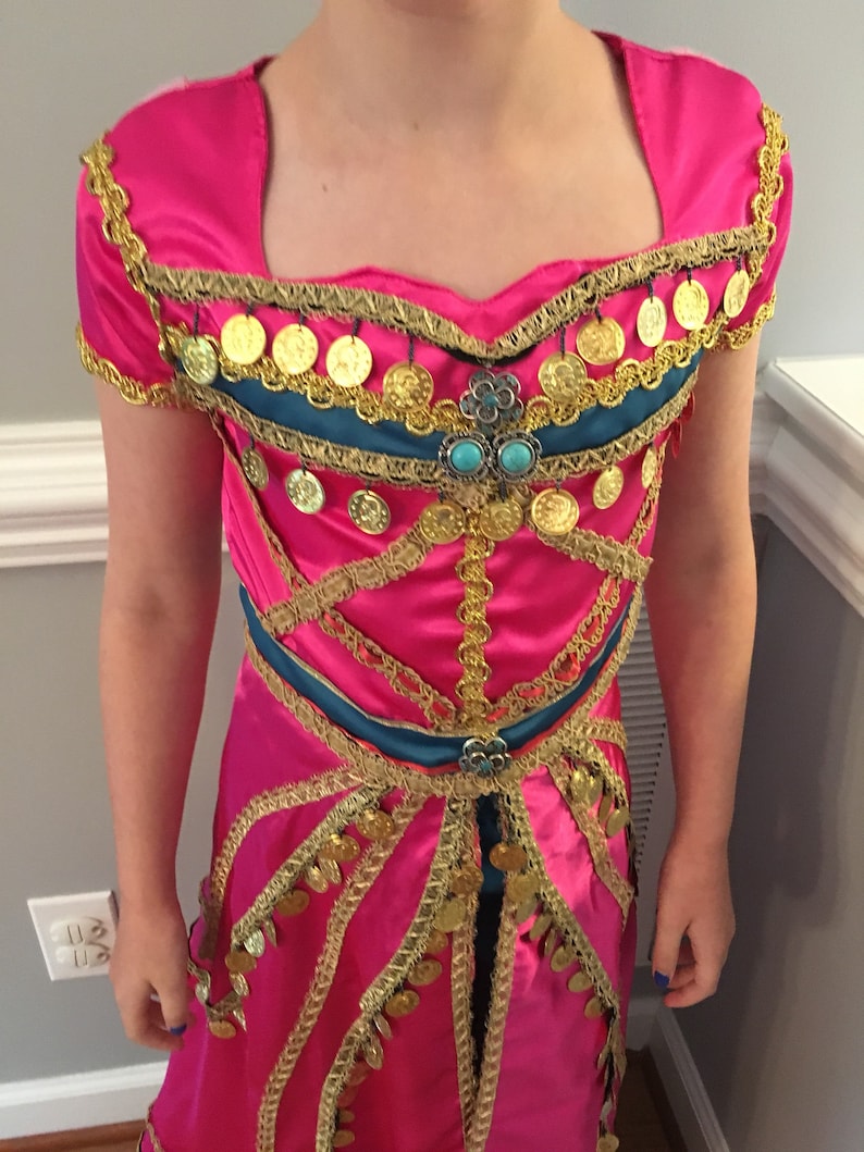 May include: A pink dress with gold and blue trim. The dress has a sweetheart neckline and is decorated with gold coins.