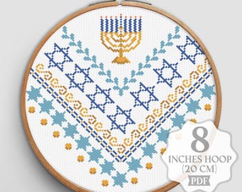May include: A cross-stitch embroidery hoop featuring a menorah and Star of David design in blue and gold. The design is on white fabric and set in an 8-inch (20 cm) hoop. The PDF pattern is available.