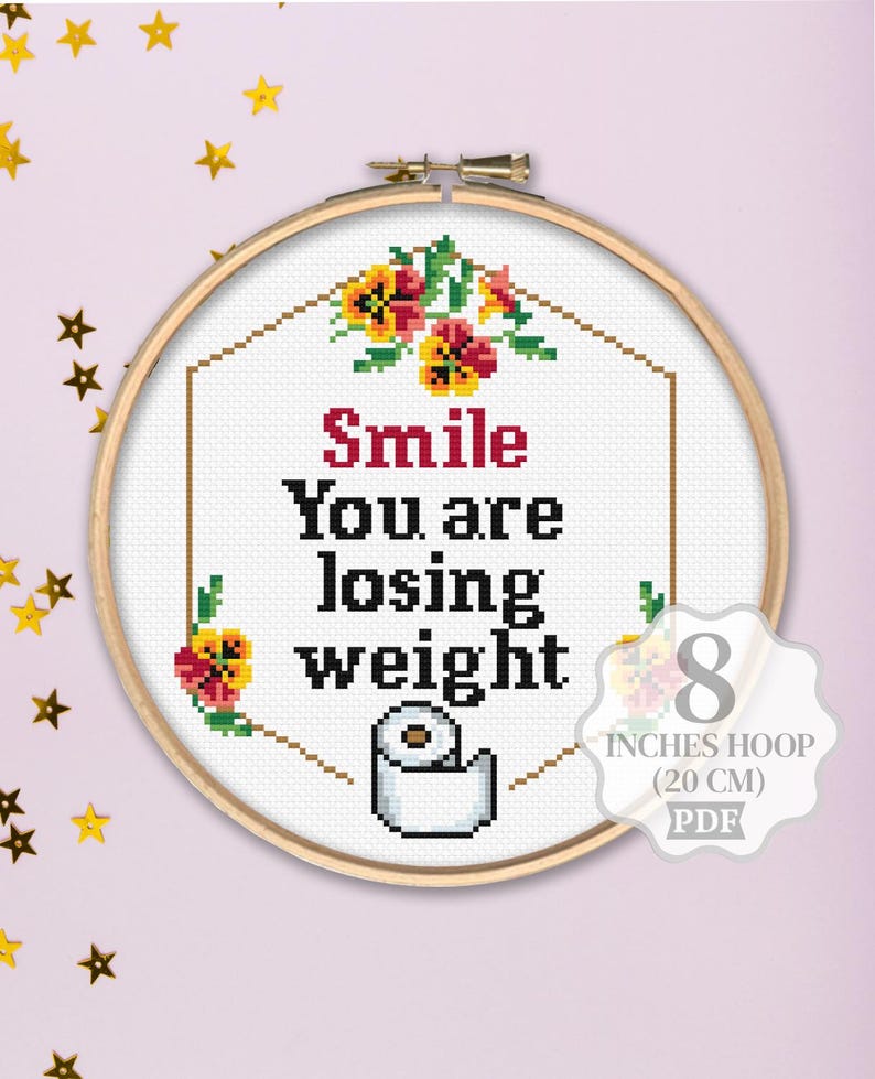 K&ouml;nnte beinhalten: Kreuzstichmuster mit einer Toilettenpapierrolle mit dem Text "Smile You are losing weight" in einem wei&szlig;en Rahmen mit roten und gelben Blumen. Das Muster ist f&uuml;r einen 20 cm gro&szlig;en Reifen.