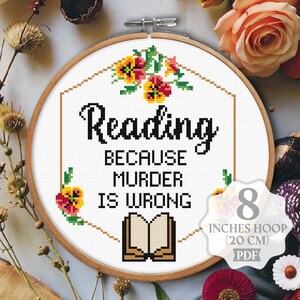 May include: Cross stitch pattern for an 8 inch hoop (20 cm) featuring a book with the text "Reading because murder is wrong". The design includes floral accents in shades of yellow, orange, and red.