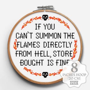 May include: A cross-stitch hoop with the text "IF YOU CAN'T SUMMON THE FLAMES DIRECTLY FROM HELL, STORE BOUGHT IS FINE." The design includes flames and skulls. The hoop is 8 inches (20 cm) in diameter.