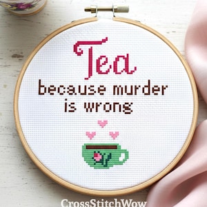 May include: Cross-stitch embroidery in a wooden hoop with the words "Tea because murder is wrong." A green teacup with pink hearts is below the text. A teacup of tea is in the upper left corner. The text "CrossStitchWow" is at the bottom.