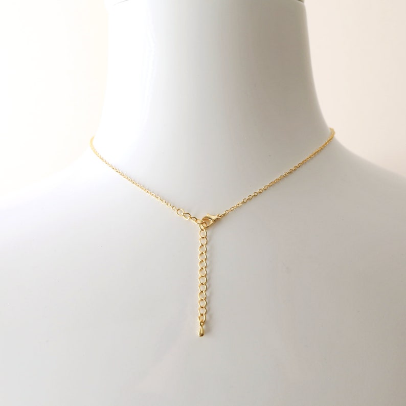 May include: A gold chain necklace with a lobster clasp closure. The chain is made of small, round links.