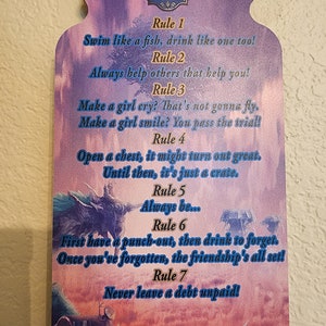 May include: A wooden sign shaped like a mason jar with a purple and blue background. The sign has the text "Salvager's Code" and lists seven rules. The rules are written in a whimsical font and include phrases like "Swim like a fish, drink like one too!" and "Never leave a debt unpaid!"