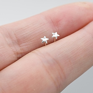 May include: A pair of silver star stud earrings. The earrings are small and delicate, and they are perfect for everyday wear.