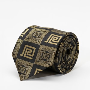 Corbata negra con estampado de llave griega dorada.