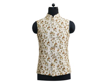 May include: A cream-colored sleeveless vest with a floral pattern in shades of brown and green. The vest has a mandarin collar and a button closure.